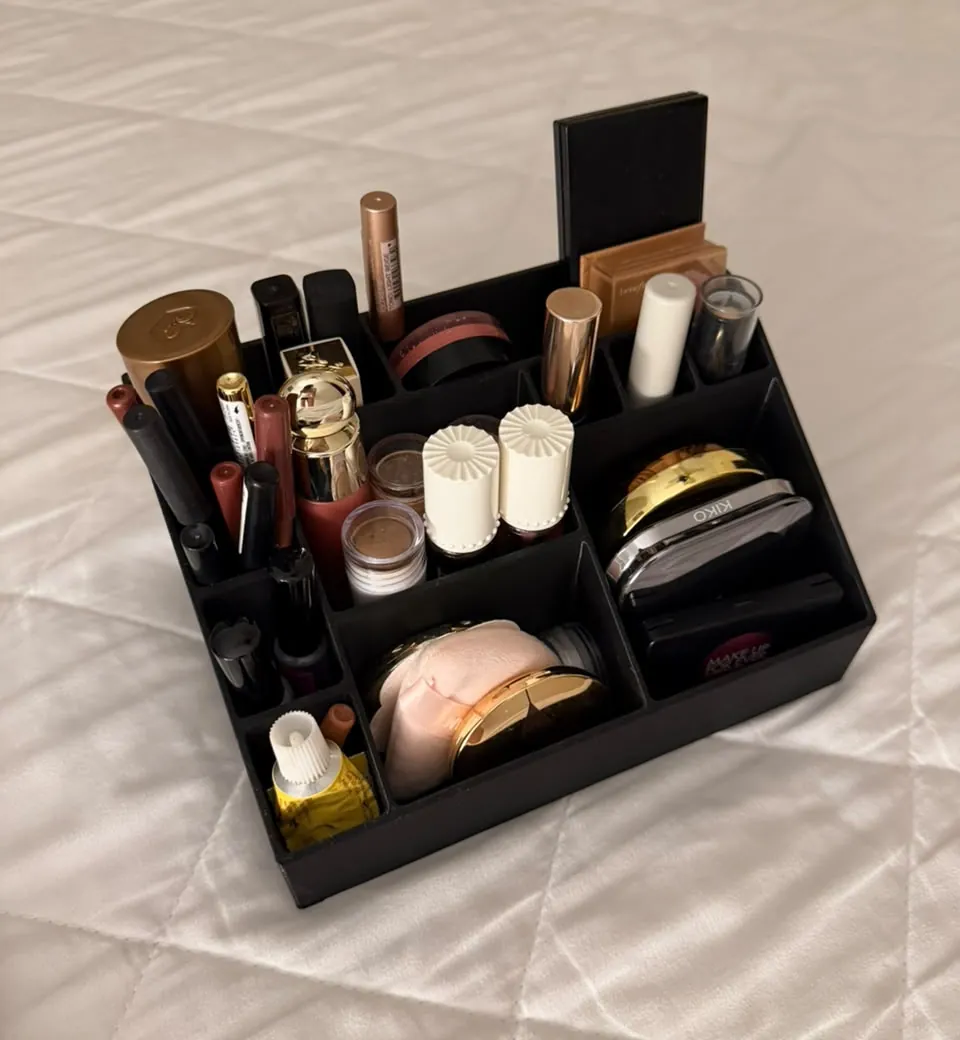 Organizador negro escalonado impreso en 3D, con compartimentos llenos de maquillaje
