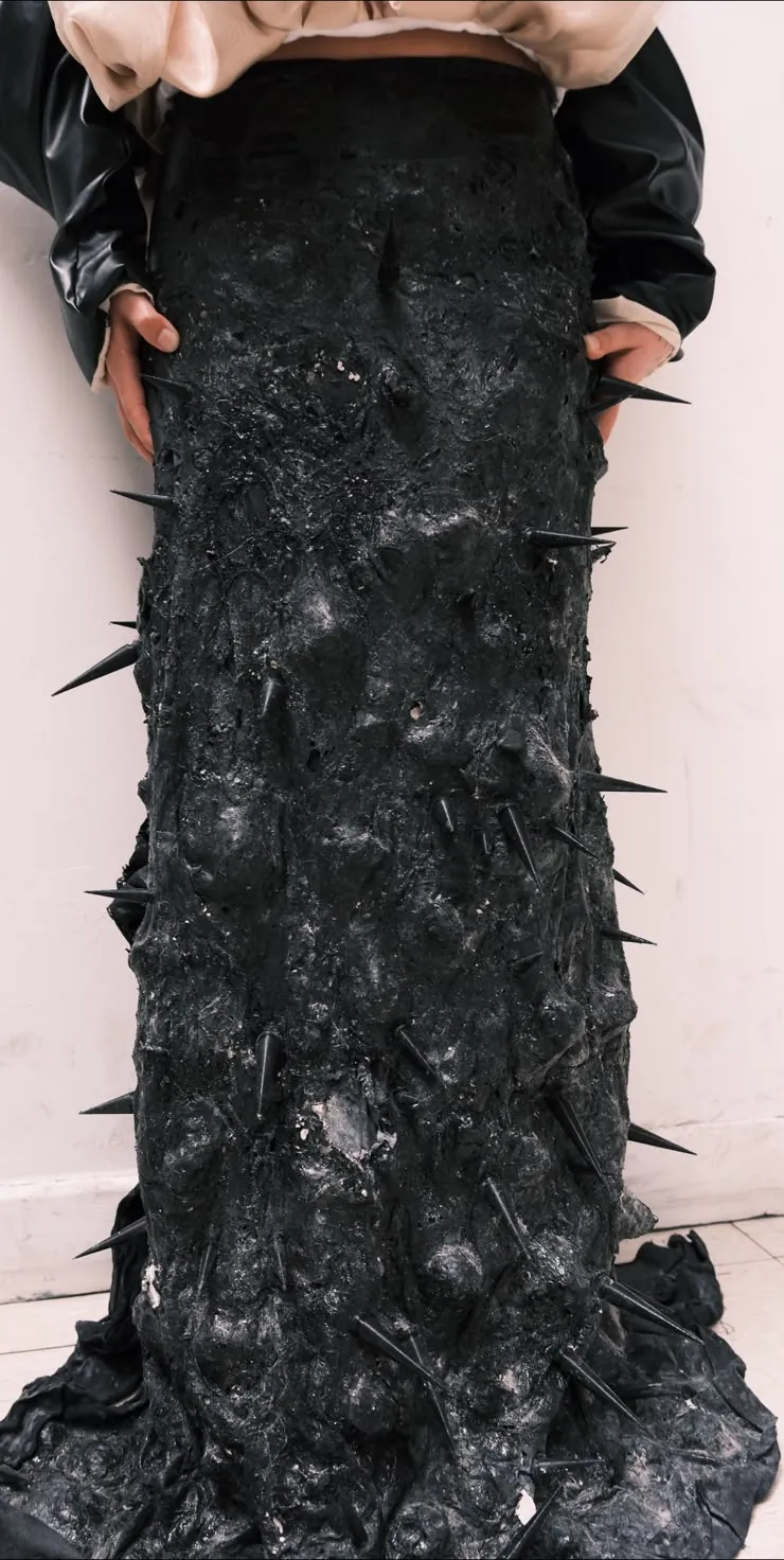 Prenda negra de textura orgánica con pinchos negros impresos en 3D