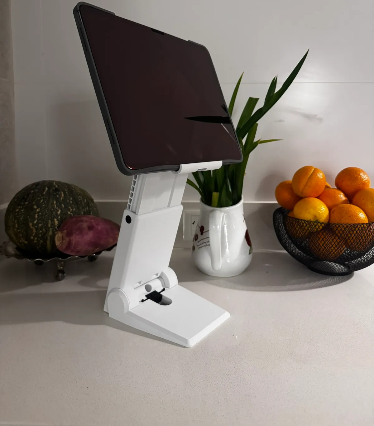 Soporte blanco impreso en 3D sosteniendo una tablet sobre una mesada